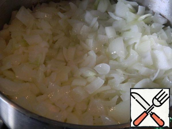 Simmer the onion in a saucepan until soft and transparent.