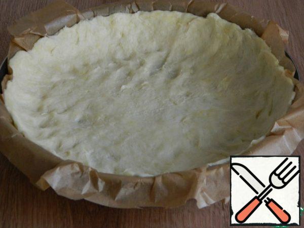 Take the dough out of the refrigerator and put it in a mold, forming the sides. I spread the dough on baking parchment to make it easier to take the cake out of the mold.
I got a shape with a diameter of 24 cm.

