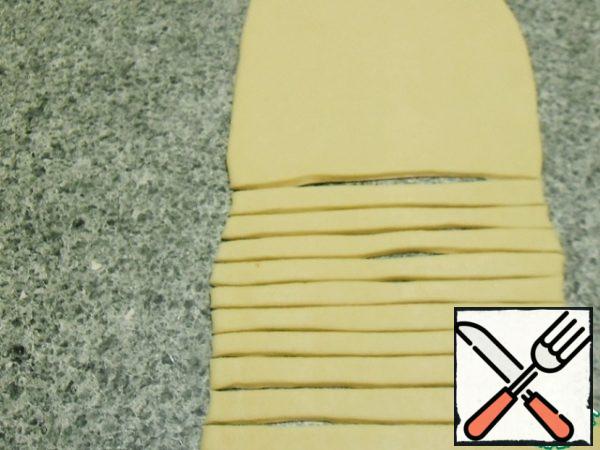 Sprinkle the table with flour, roll out into a layer (about 15 cm wide, 5-7 mm thick).
Cut into ribbons.
