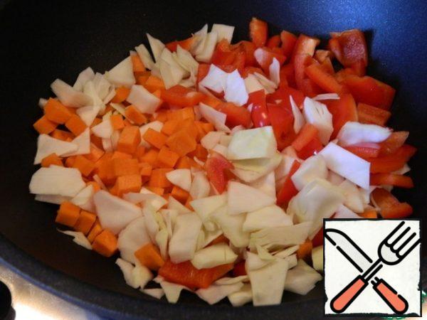 Heat the oil in a frying pan and put the carrots, cabbage, pepper on it.