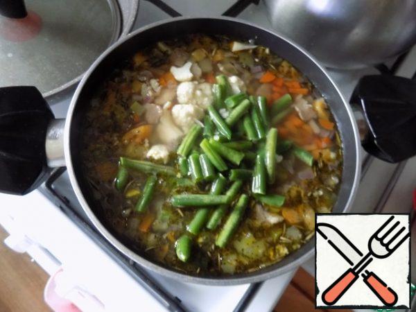 Spread in the soup cauliflower, beans. Cook for 2 minutes. These vegetables cook very quickly and again we do not need them to boil.