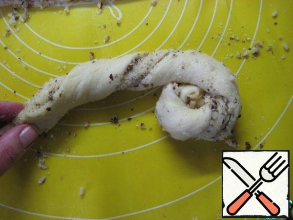 Take a piece by two edges and, slightly stretching, begin to twist into a flagellum, and then wrap the twisted flagellum with a "snail". The filling will be a little runny, but that's okay! Carefully assemble and sprinkle the top of the rolls.
