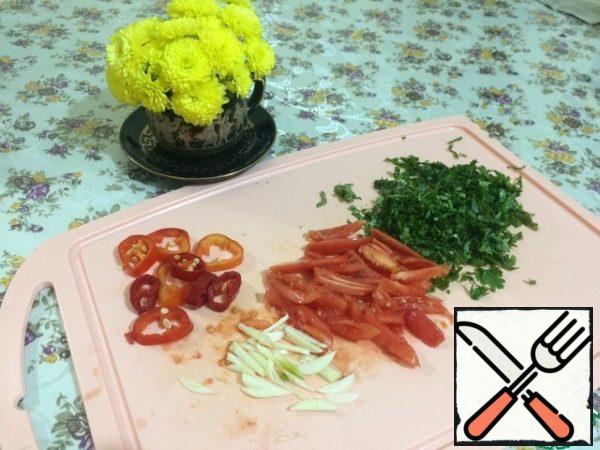 While the paste cools, prepare the sauce for the lamb. To do this, pour boiling water over the tomatoes and remove the skin. Cut into narrow slices. Finely chop the cilantro, hot pepper, garlic.