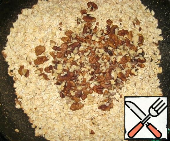In a dry pan fry, stirring constantly, until Golden brown oatmeal and walnuts (nuts pre-slightly grind). Remove from heat and allow to cool.