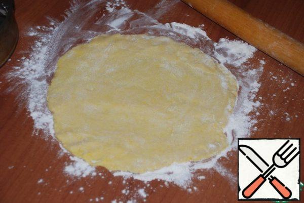 Through hour dough get, roll out on size forms (I have 26 centimeters) on podpylennom flour the table. Put in the form and put in the oven at 180-200 degrees (look at your oven) for 15 minutes. During this time, peel the apples for the filling (500 g), grate on a medium grater. You can sprinkle with lemon juice.