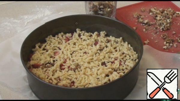 Take the dough and rub it on top on a coarse grater. We will get three cakes, so divide the dough and filling into three parts. Bake the cakes in a preheated 180 degree oven for 30 minutes.

