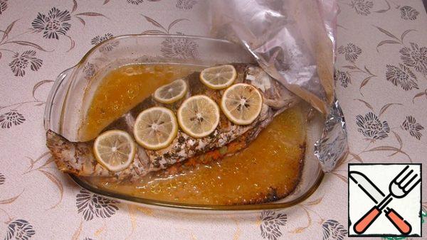 The remaining half of the lemon cut into slices, spread on the fish.
Cover with foil and in the oven for 30-35 minutes at 180 degrees.
Then remove the foil and another 30 minutes in the oven. Look at your oven and the weight of the fish.