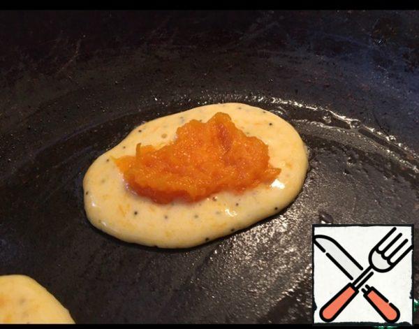 The finished dough is poured into the pan, put a teaspoon of mashed pumpkin puree on top.