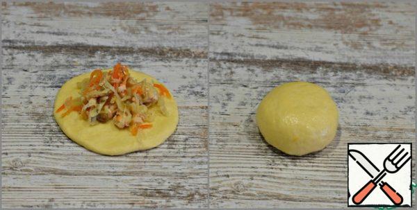 Roll out a cake with a diameter of 10-11 cm from each blank . In the middle of the cake, put a tablespoon of filling with a slide, carefully blind the edges of the cake, forming a round pie.
