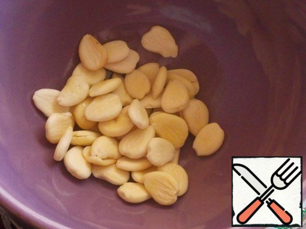 When the jam is boiled for the third time and remains to cool, we will prepare the filling. Pour boiling water over almonds or apricot seeds and leave for 10-15 minutes. Then drain the water and clean the nucleoli. We put the peeled kernels of nuts on paper towels so that all the excess moisture goes away!
