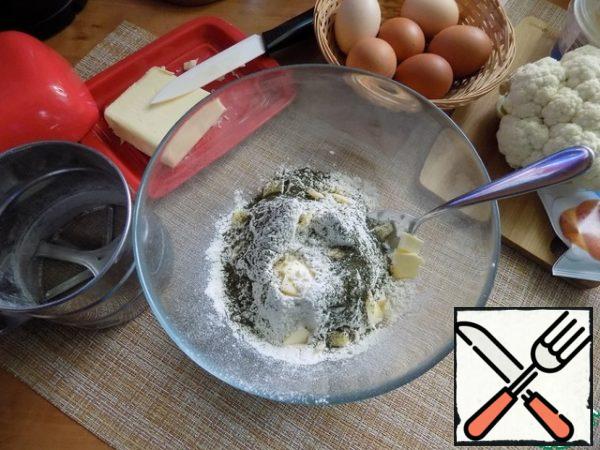 Sift the flour into a bowl, where we will knead the dough. Put baking powder, salt, dry dill. Stir. Put the chopped butter.