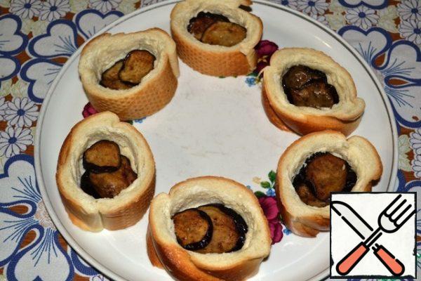 Put two eggplant rings in each recess, press down with a spoon.
