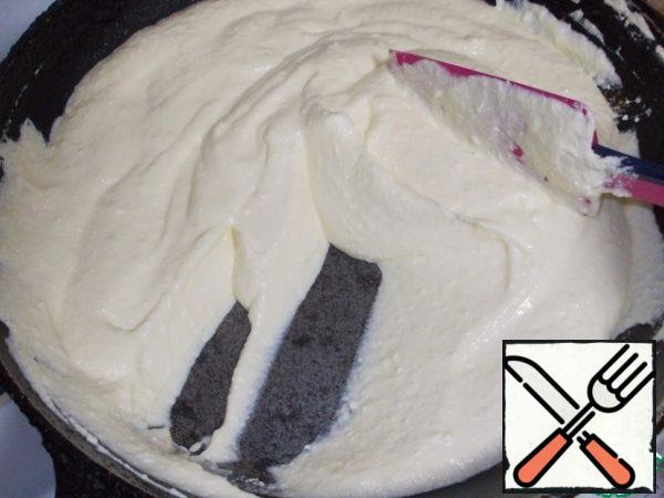 As the mass heats up, it will liquefy. Add the butter and continue to warm up the mass.
