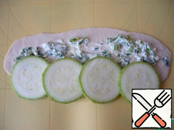 Thin slices cut the zucchini. On one piece of dough, place 4 slices of zucchini, slightly overlapping each other.