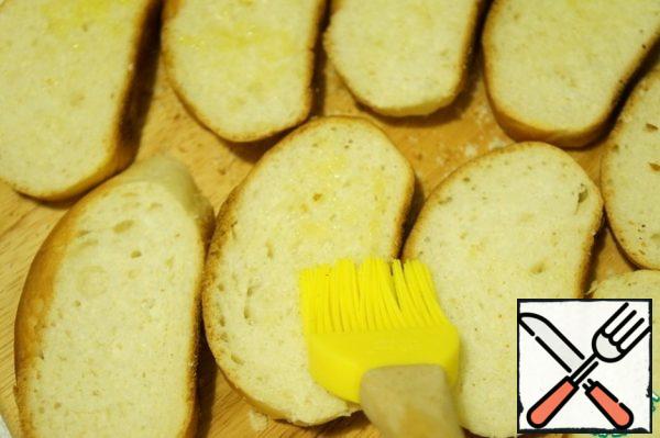 Brush the slices of the loaf with olive oil, dry in a frying pan.
Cut the garlic clove in half and lightly rub each slice of bread.
