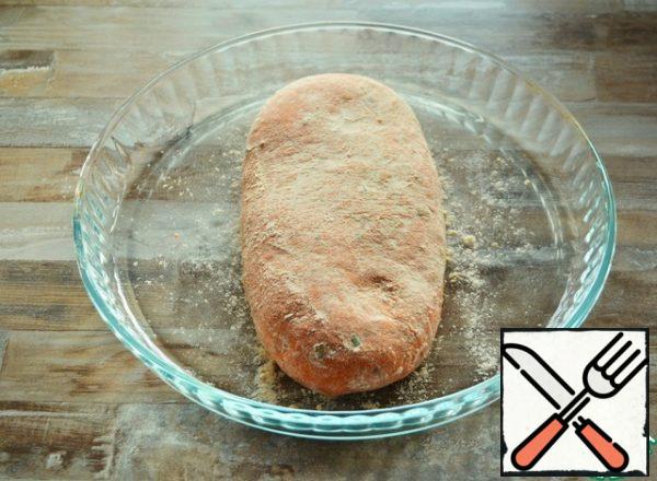 Then stretch this ball slightly to get the shape of a loaf. Generously coat the bread with flour and place on a baking sheet or in a mold.