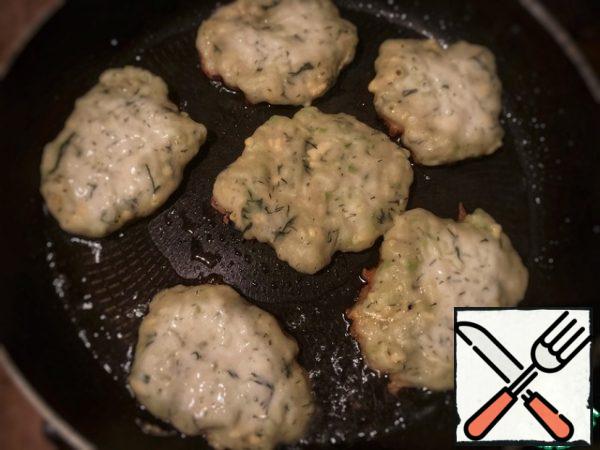 Preheat a frying pan with oil, put a tablespoon of zucchini-cheese dough on it, forming round or oval pancakes.
