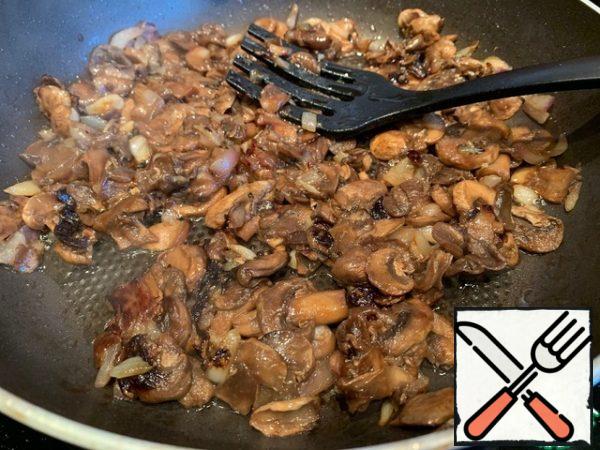 In a hot frying pan, pour vegetable oil and fry the onion until transparent. Add the chopped mushrooms and fry for about 10 minutes until all the liquid has evaporated.