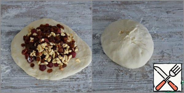 Work surface sprinkle (quite a bit!!!) flour, roll out the dough into a layer, put the nuts and dried fruits on the dough and carefully knead them into the dough.
Nuts pre-calcinate in a dry pan, raisins and cherries wash and dry well. Cherry cut in half.