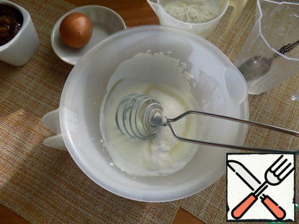 Pour kefir into a bowl, pour baking powder into it. Whisk with a whisk and wait for the reaction. Add sugar, vanilla and whisk everything together again, mash.
