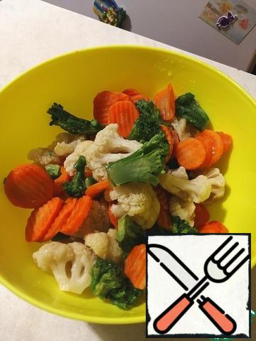 Broccoli and cauliflower disassemble into inflorescences, carrots cut into circles. Pour boiling water over the broccoli and cauliflower. Put all the vegetables in a bowl.