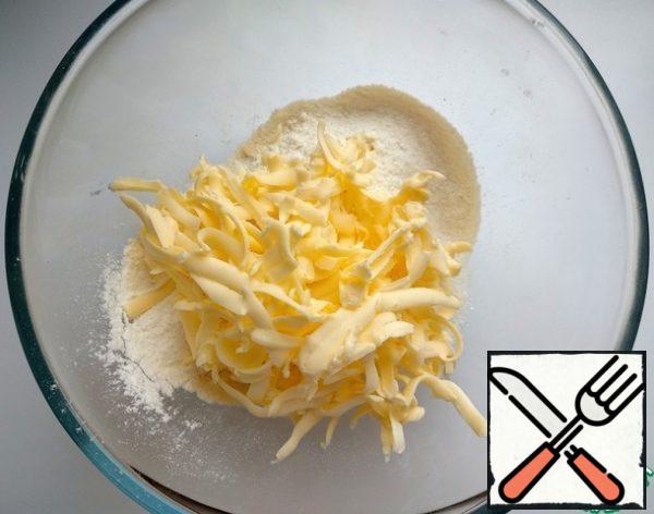 Next, prepare the sand crumbs. To do this, mix the sugar with flour and add cold oil, grated on a coarse grater.