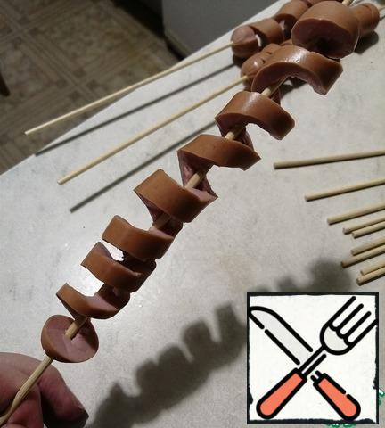 Sausages put on a long skewer and make cuts in a circle and stretch into a spiral.