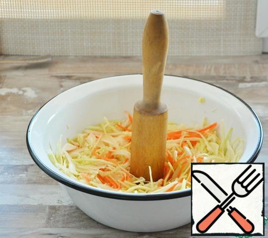 And wooden pestle with a little "tread" cabbage. It is not necessary to mash or RUB it strongly. Just tap 5-7 times with a pestle up and down and mix the cabbage with the carrot.It is more convenient to do it in portions. I usually divide the entire volume into 4 parts and "stomp" the cabbage in 4 calls