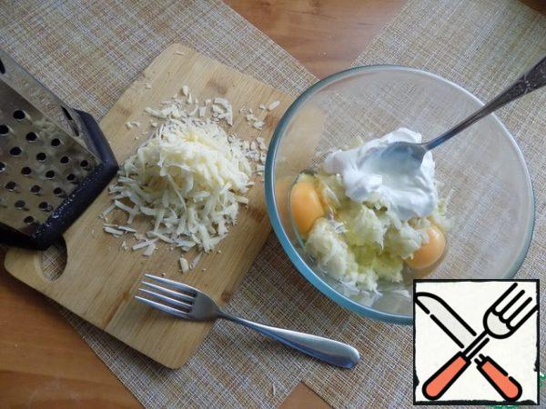 Break the eggs, put sour cream. Stir with a fork. Grate the cheese on a medium grater.
