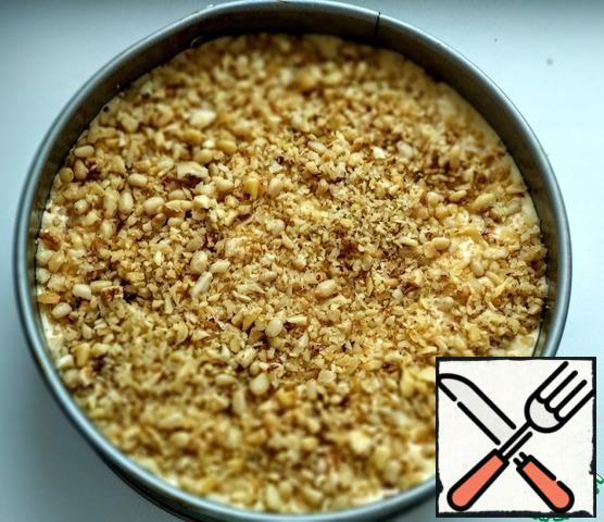 Split baking dish (diameter 20 cm) lay baking paper, grease with vegetable oil. Put the dough in it, smooth. Sprinkle the remaining nuts on top. Bake in the oven, preheated to 180 degrees, 35-40 minutes. check Readiness with a wooden skewer.