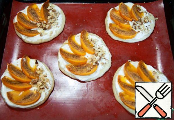 Brush the tortillas with white sauce. Lay out the slices of persimmon and nuts. Bake the pizzettes for 10-15 minutes.
