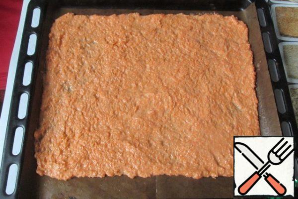 Cover the baking sheet with parchment, brush it with a piece of butter and lay out the carrot dough. Flatten the dough into a layer about 30 x 40 cm in size.
