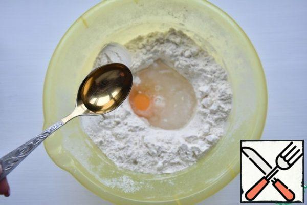 In a bowl, sift the wheat flour. In the center make a hole where beat in an egg. Pour warm water, add salt.