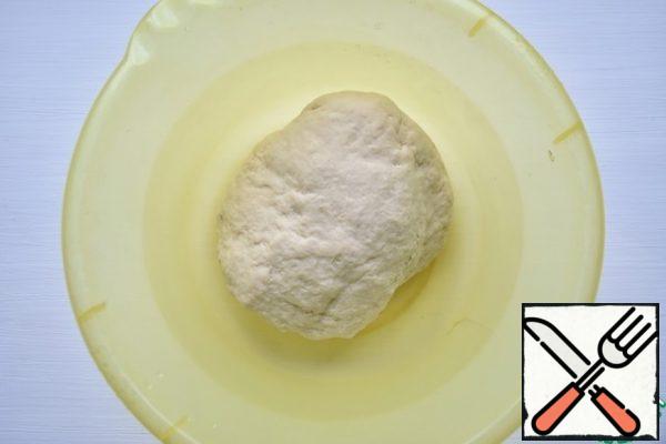 For convenience, put the semi-finished product on the countertop and continue to knead on it for 7-10 minutes. The dough is elastic, but quite dense.
The finished dough is wrapped in foil and put in the refrigerator for half an hour.