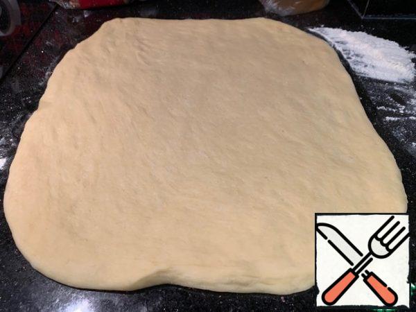 Sprinkle the table with flour and roll out the dough into a layer about 5 mm thick.
