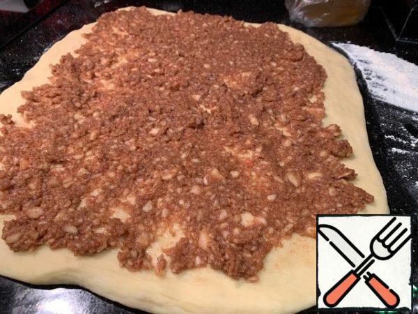 Spread the filling evenly. Roll the dough tightly into a roll.

