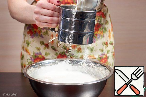 In two steps, sift the flour to the eggs. Distribute it over the entire area of the foam, otherwise it will sink to the bottom under its weight and it will be very difficult to mix it.
