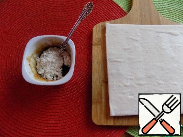 The dough layer should be removed from the refrigerator and defrosted. For one layer of dough, we will need 6 tsp of jam or 3 tbsp.l. Mix the jam with flour. This is done so that the jam does not leak onto the baking tray during the baking process. Flour can be replaced with starch. I don't see much difference.
