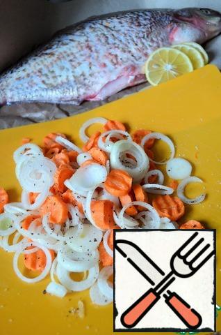 Carrots and onions cut, add salt and pepper, mix well.
RUB the fish inside and out with lemon, salt and a mixture of peppers.