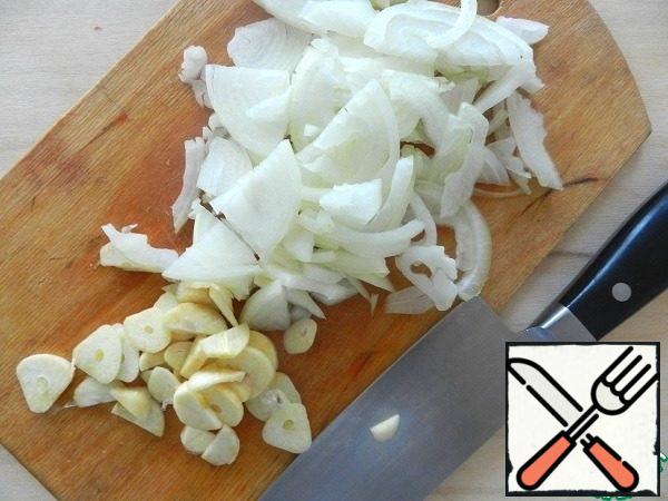 Peel the onion, cut a quarter into rings, garlic-plates.