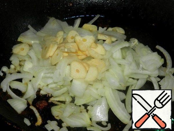In the same pan fry the onion and garlic until transparent.