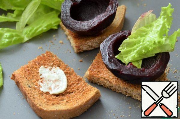 Cut the bread into small pieces, cut the bottom of the beetroot slightly.
Spread a little cheese mixture on a piece of bread.
Put beets on it, put lettuce leaves on one side (imitate radish tops).
