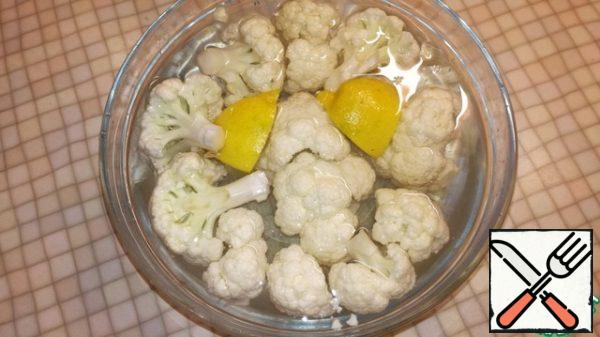 Cauliflower disassemble into small inflorescences. Transfer to a deep bowl and cover with water to cover the cabbage. Squeeze lemon juice in a bowl with cabbage, peel add there same. Leave on for 20 minutes.