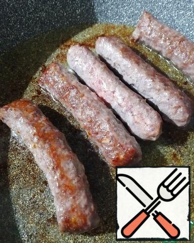 Sausages fry in a frying pan until tender.