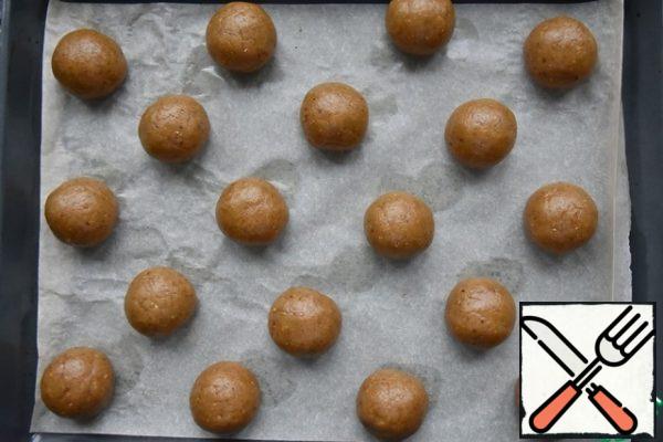 Divide the dough into pieces, about 55 grams each. Roll the balls and place them on a baking sheet covered with parchment paper. Bake cookies in the oven, preheated to 200 degrees for no more than 15 minutes.