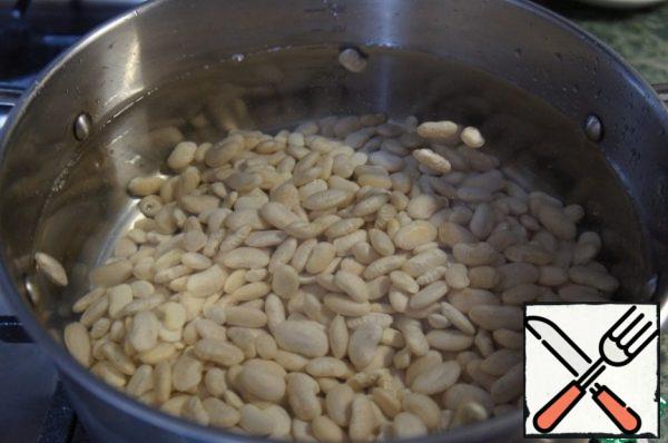 Beans soak overnight in cold water. Drain the water, rinse the beans. Pour the beans 2.5 liters of water and bring to a boil, remove the foam. The first 10 minutes boil on strong fire. Reduce the heat and cook until almost tender. While the beans are cooking, prepare the vegetables.