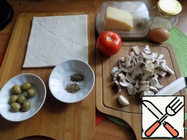 The layer of the finished dough needs to be thawed. It's fast. We are preparing everything for the rolls. Peel the mushrooms, cut them into plates.
