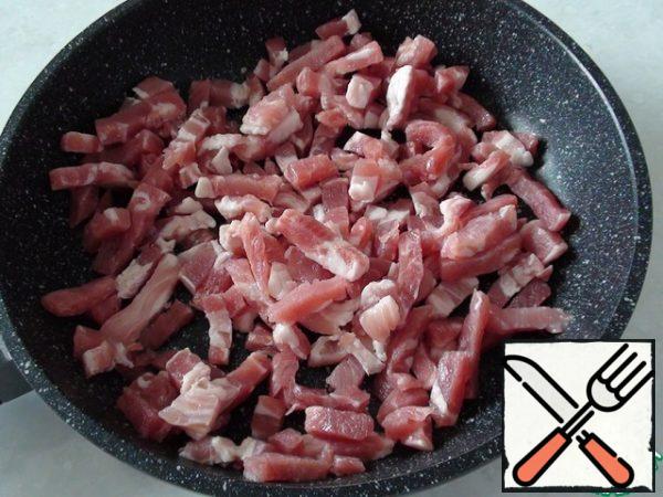 While the pan boils, spread on a small non-stick frying pan 150-200 gr. not too greasy bacon and over high heat quickly fry, stirring CONSTANTLY (otherwise it will burn).