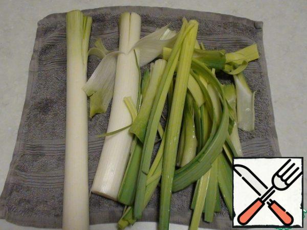 Cut the dark part of the leek leaves and discard, cut the white part from the light green to make it easier to wash, divide the green part into leaves and wash in running water from the ground and sand. Shake off the water and put on a towel to drain the remaining water.