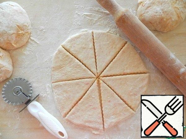 The resulting dough is divided into 4 parts. From each roll out a circle 3-5 mm thick. Cut into 8 sectors.
